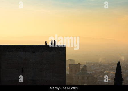 Les gens contempler la ville espagnole de Granada à partir de la forteresse Alcazaba de l'Alhambra Palace pendant le coucher du soleil. La Cathédrale de Grenade peut être vu au-delà. Banque D'Images