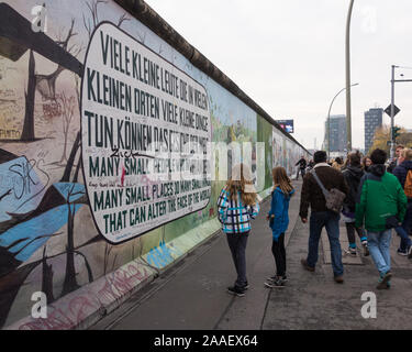 Les visiteurs de la East Side Gallery à Berlin admirer une peinture murale peinte avec des mots en allemand et en anglais sur un vestige du Mur de Berlin Banque D'Images