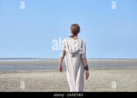 Femme en robe de lin sur le front de mer Banque D'Images