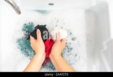 Blanchisserie lavabo avec différents vêtements clored lavage des mains Banque D'Images