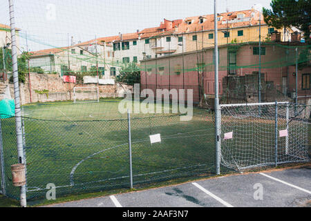 Petit terrain de football vert entre les vieilles maisons en Italie Banque D'Images