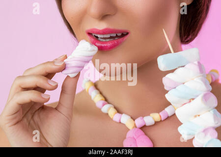 Heureux belle femme avec des guimauves sur la brochette sur fond rose Banque D'Images