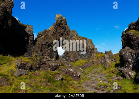 Le trou du rocher à glacier Snaefellsjokull et rock formation à Djupalonssandur Dritvik, plage et parc national Snaefellsjokull, Snaefellsnese peninsul Banque D'Images