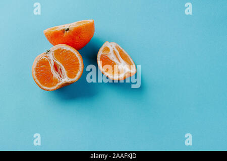 La moitié des clémentines et un quart sur un fond bleu avec copie espace Banque D'Images