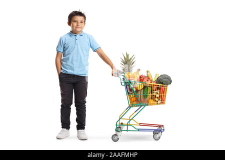 Portrait d'un jeune garçon posant avec un mini panier plein de nourriture isolé sur fond blanc Banque D'Images