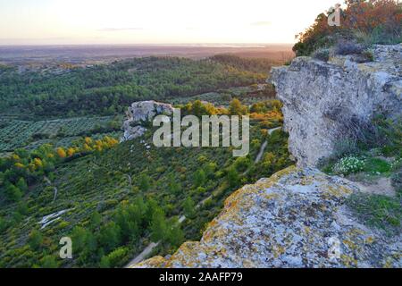 Vue du coucher de soleil sur les Alpilles vallée avec green olive tree groves ci-dessous l'historique village fortifié Les-Baux-de-Provence, dans les Bouches du Rhône, prouvé Banque D'Images