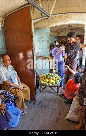 Un vendeur vend des fruits aux passagers sur le train circulaire à Yangon Myanmar Birmanie Banque D'Images