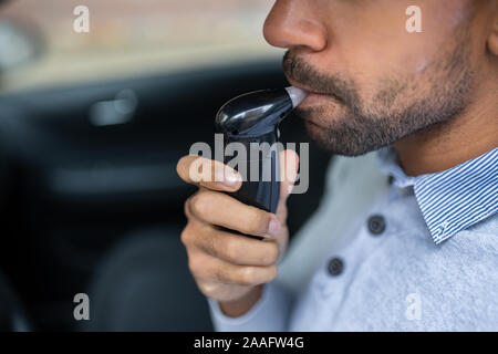 Homme assis à l'intérieur car la prise d'alcool Test Banque D'Images