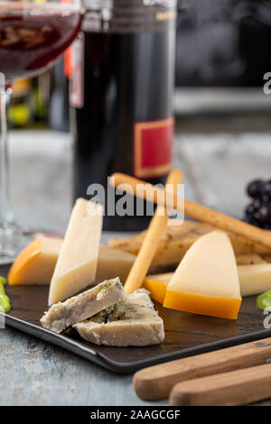 Assiette de fromage servi avec des raisins, des fraises, des craquelins et des écrous sur un fond de bois Banque D'Images