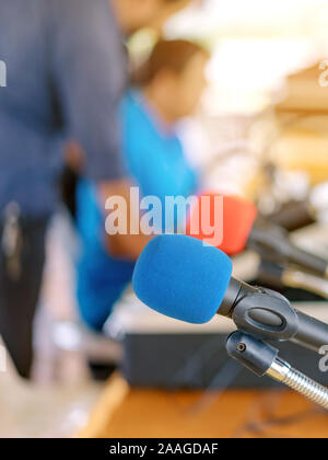 Deux microphones avec éponges bleu et rouge sur un support placé avec écouteurs sur la table avec l'image du barbouillage du technicien audio a été l'installation et le sev Banque D'Images