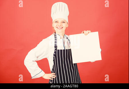 Woman in hat cook et tablier. chef professionnel en cuisine. Cuisine. menu du restaurant. Suivre un régime culinaire. happy woman la cuisson des aliments sains par recette. Femme au foyer avec livre de cuisine saine. L'alimentation biologique. Banque D'Images