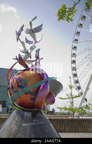 LIVERPOOL, Angleterre, Royaume-Uni - Juin 07, 2017 : la paix sur terre sculpture en l'honneur de John Lennon avec la roue de l'écho de Liverpool à l'arrière de Keel Wharf, Banque D'Images