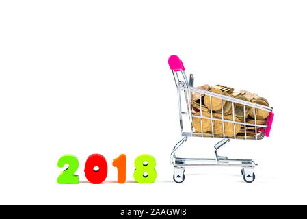 2018 Texte en bois et des piles de pièces de monnaie avec panier ou chariot de supermarché, isolé sur blanc, planification financière et opérationnelle sur l'année 2018 concep Banque D'Images