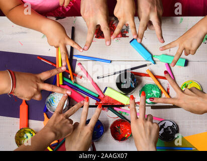 Art et idée concept. Fournitures d'art pour enfants et adultes ou en mains montrent la victoire sur fond blanc. Mains tiennent des marqueurs, crayons et peintures. Les mains d'artistes à l'aide de modèles et du papier de couleur Banque D'Images