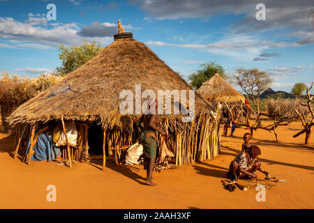 L'Éthiopie, de l'Omo, Turmi, Hamar village tribal, les femmes et les enfants à l'extérieur de maison traditionnelle en bois avec toit de chaume Banque D'Images