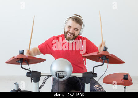 Émotions, batterie électronique et personnes concept - jeune homme batteur jouant du tambour. Banque D'Images