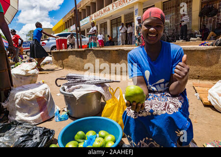 Un commerçant vendant mangues au marché de Mzuzu, Malawi, donne le feu vert. Banque D'Images