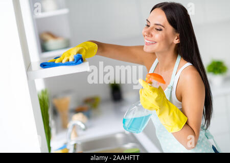 Côté positif de la photo de profil cheerful girl laver des étagères dans la cuisine spray jaune en caoutchouc Tapis bleu gants confort sentir in modern house Banque D'Images