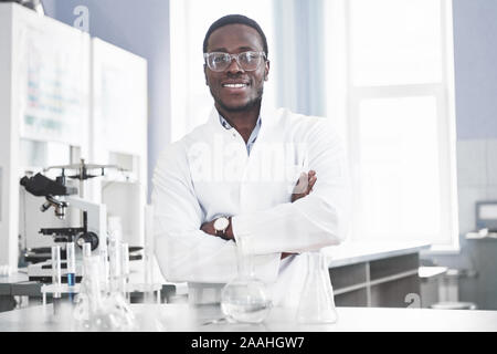 Le scientifique travaille avec un microscope dans un laboratoire effectuant des expériences et des formules. Banque D'Images