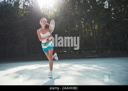 Une jolie femme portant un vêtement de tennis à la cour Banque D'Images