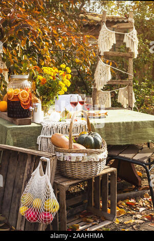 Beau dîner de fête dans le jardin parmi les feuilles d'automne et de citrouilles avec du vin et des tartes. Jour de Thanksgiving concept. Banque D'Images