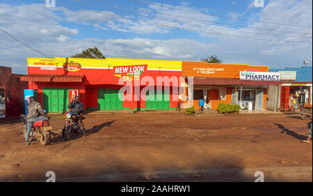 De faible hauteur, typique des magasins et bâtiments colorés peints avec des annonces dans une communauté villageoise, région de Kampala, Ouganda, District central Banque D'Images