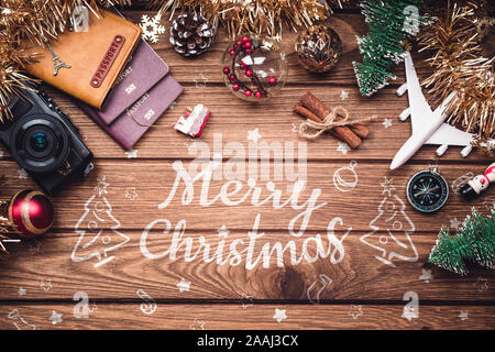 Concept de voyage de Noël. Avion blanc, passeport, appareil photo et décoration décorations de Noël sur fond de bois rustique. Merry xmas and happy New Y Banque D'Images
