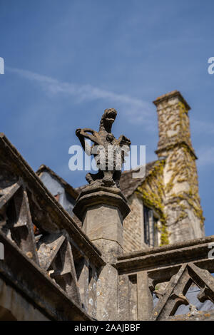 Statue de gargouille en pierre sculpté de Rock sur le toit d'une église dans les Cotswolds en Angleterre, Royaume-Uni. Banque D'Images