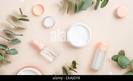 Télévision jeter la composition avec les matières organiques naturelles produits cosmétiques sur fond beige. Vue supérieure de la crème pour les mains en pot, huile essentielle, lotion pour la peau et de l'eucalyptus Banque D'Images