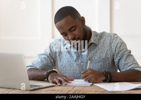 L'accent African American male portable étudiant à prendre des notes Banque D'Images