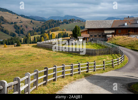 Clôture et chemin rural menant à un chalet en bois de montagne dans le célèbre Alpe di Siusi vallée sur les Dolomites, le Tyrol du Sud en Italie Banque D'Images