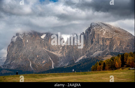 Paysage de montagne avec de la Dolomite pic rocheux couvert de nuages et les personnes non reconnus à la randonnée dans le célèbre Alpe di Siusi vallée en Italie Banque D'Images