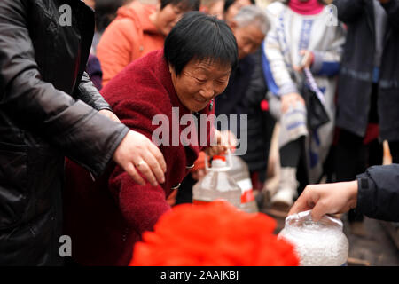 (191122) -- YICHENG COUNTY, 22 novembre 2019 (Xinhua) -- les villageois de recueillir l'eau après un bien en eau profonde a commencé le pompage de l'eau souterraine dans la région de Nanling Village de Yicheng County, le 20 novembre, 2019. Comme l'interrupteur a été tiré, l'eau jaillit à partir de 403 mètres vers le bas sous. Village Nanling, bien en eau profonde a été mis en service sur un début de matinée d'hiver. Dans le passé, le village, s'étendant sur les ravins de la montagnes Zhongtiao dans le nord de la Chine, s'est appuyée uniquement sur des puits de boue pour stocker sa précieuse eau potable pendant des siècles. Hanté par la peur de la sécheresse, des générations ont rêvé de Banque D'Images