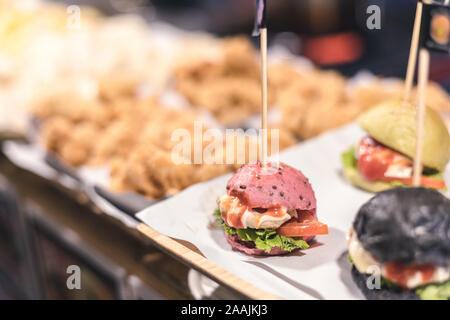 Mini burger rose avec d'autres couleurs stick avec drapeau stick sur le dessus Banque D'Images
