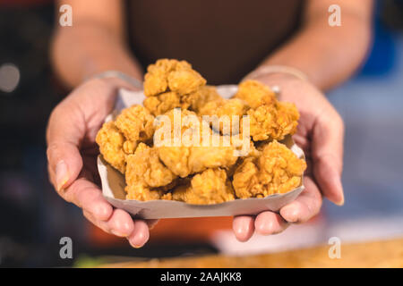 Golden chicken fried dans le papier sur la plaque de la femme Banque D'Images