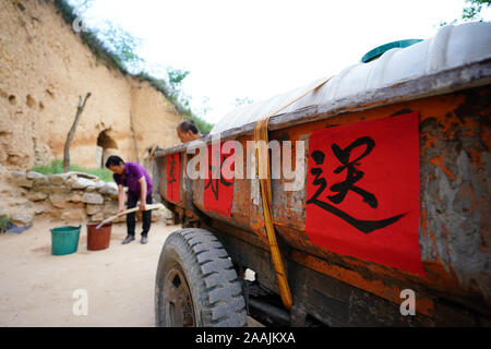 (191122) -- YICHENG COUNTY, 22 novembre 2019 (Xinhua) -- Un village deux aide à distribuer l'eau à un villageois de Nanling Village de Yicheng County au Nord la province de Shanxi, le 3 juillet 2019. Comme l'interrupteur a été tiré, l'eau jaillit à partir de 403 mètres vers le bas sous. Village Nanling, bien en eau profonde a été mis en service sur un début de matinée d'hiver. Dans le passé, le village, s'étendant sur les ravins de la montagnes Zhongtiao dans le nord de la Chine, s'est appuyée uniquement sur des puits de boue pour stocker sa précieuse eau potable pendant des siècles. Hanté par la peur de la sécheresse, des générations ont rêvé de Banque D'Images