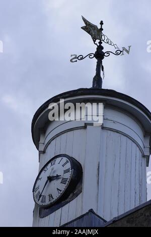 La tour de bois blanc sur un bâtiment avec une horloge et girouette en haut Banque D'Images