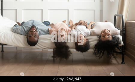 La famille africaine se trouve sur le bas des têtes de lit looking at camera Banque D'Images