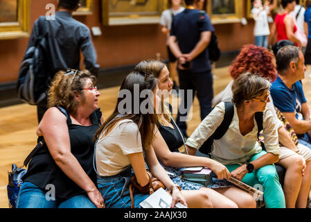 Beaucoup de gens assis sur et en regardant les œuvres d'art dans le musée du Louvre, le plus grand musée d'art et monument historique à Paris, France. Banque D'Images