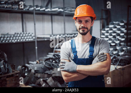 Portrait d'un jeune travailleur dans un casque à une grande usine de travail des métaux. Shiftman sur l'entrepôt de produits finis Banque D'Images