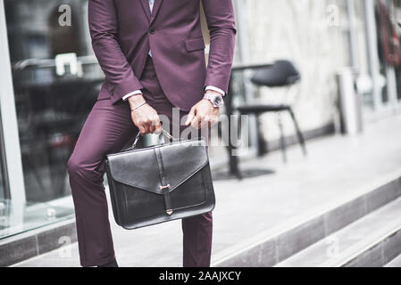 Jeune homme avec un porte-documents à proximité d'un beau bureau. Réunion d'affaires. Banque D'Images