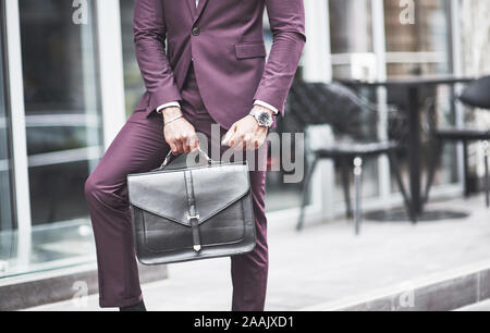 Jeune homme avec un porte-documents à proximité d'un beau bureau. Réunion d'affaires. Banque D'Images