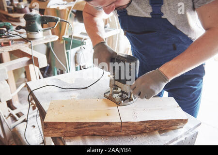 Portrait d'un charpentier de vêtements de travail dans l'atelier du menuisier. Banque D'Images