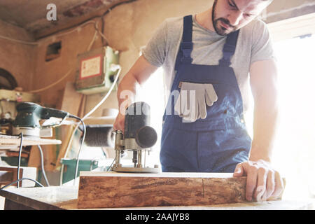 Portrait d'un charpentier de vêtements de travail dans l'atelier du menuisier. Banque D'Images