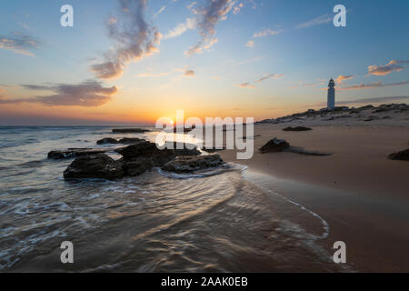 Phare du cap Trafalgar au coucher du soleil avec des vagues se brisant sur beach, Los Caños de Meca, Costa de la Luz, province de Cadiz, Andalousie, Espagne, Europe Banque D'Images