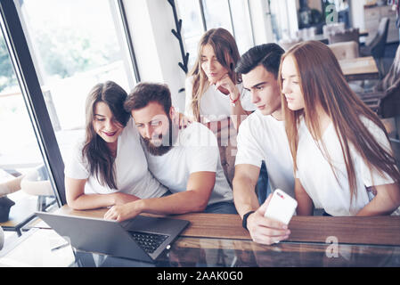 Un groupe de jeunes avec des gadgets et un ordinateur portable organiser une séance de brainstorming et de communiquer les uns avec les autres. Le concept de l'élaboration d'une jeune entreprise Banque D'Images