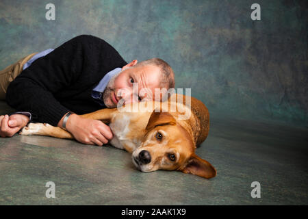 Studio portrait of man avec Redbone Coonhound Banque D'Images