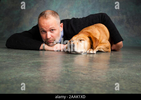 Studio portrait of man avec Redbone Coonhound Banque D'Images