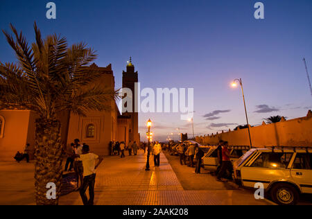 Grand Taxis et la mosquée au crépuscule, Zagora. La vallée du Draa, Maroc Banque D'Images