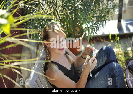 Junge Frau auf der Terrasse - Jeune femme au jardin Banque D'Images